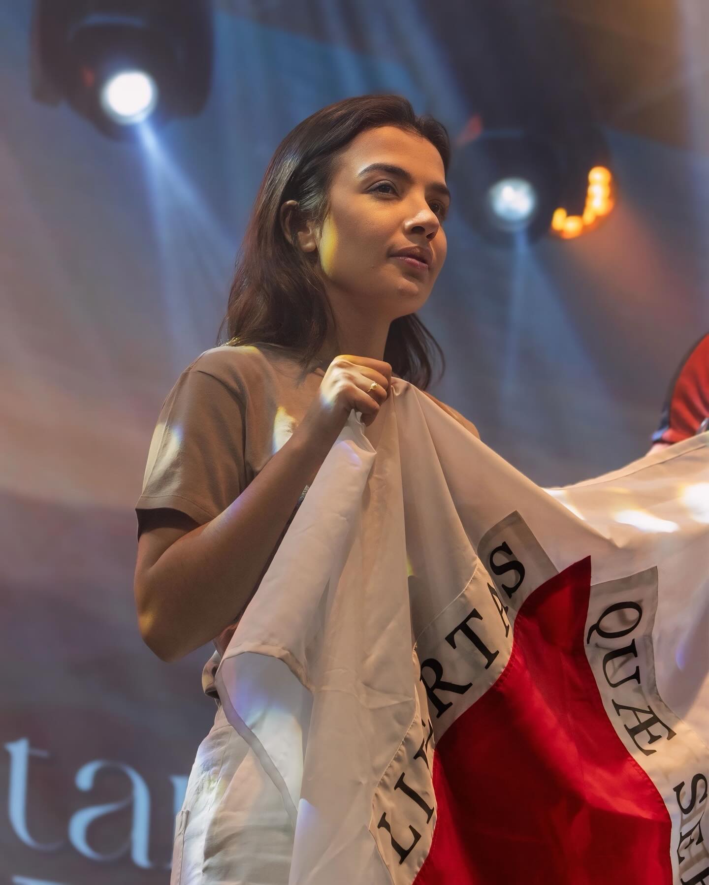 Chiara Biondini com a bandeira de Minas diante de uma multidão